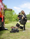 Girl in fireman`s suit against a fire engine preparing to overcome an obstacle course