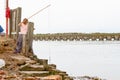 A girl fishing for crabs at the bank of river Blyth in Southwold, UK