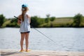 Girl fishing from a dock on a lake or pond. Royalty Free Stock Photo