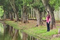 Girl fishing, standing in front of a lake, holding a fishing rod Royalty Free Stock Photo