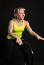 Girl on a fitness trampoline on a black background in a yellow t-shirt black fit sport, activity lifestyle vitality Royalty Free Stock Photo