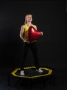Girl on a fitness trampoline on a black background in a yellow t-shirt black woman, exercise fitness lifestyle vitality Royalty Free Stock Photo