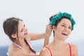 Girl fixing her friends hair rollers Royalty Free Stock Photo