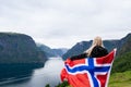Girl with the flag of Norway looks at the fjord Royalty Free Stock Photo