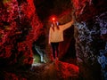 Girl with flashlight explores dark creepy abandoned underground limestone cave