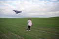 A girl flies a kite on a large green field