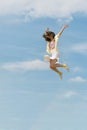 Girl flies in the sky raising her hands. Concept of freedom and happiness. Young woman jumping through the air Royalty Free Stock Photo