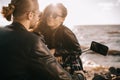 girl flirting with biker while he sitting on motorcycle near sea Royalty Free Stock Photo