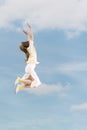 Girl floating in the air against the background of blue sky and clouds. Carefree young woman during jump Royalty Free Stock Photo