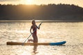 Girl floating on supboard on a river or lake. Royalty Free Stock Photo