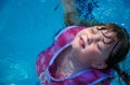 Girl floating in swimming pool Royalty Free Stock Photo