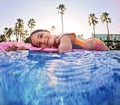 Girl floats on pink inflatable in the pool. Beach resort vacation by the sea. Winter and summer seaside resort holidays Royalty Free Stock Photo