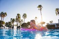 Girl floats on pink inflatable in the pool. Beach resort vacation by the sea. Winter and summer seaside resort holidays Royalty Free Stock Photo