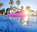 Girl floats on pink inflatable in the pool. Beach resort vacation by the sea. Winter and summer seaside resort holidays Royalty Free Stock Photo