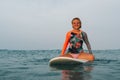 Girl floats sitting on the surf on horseback and smiling Royalty Free Stock Photo