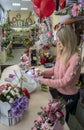 Girl, florist-designer makes a beautiful, festive bouquet of flowers in a flower shop