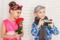 Girl with flower and boy holding camera Royalty Free Stock Photo