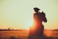 Girl with flowers wreathwhile riding horse at sunset