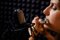 Girl flute in headphones player plays in recording studio, close-up. Record wind musical instruments with a professional