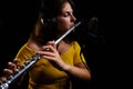 Girl flute in headphones player plays in recording studio. Record musical instruments with a professional microphone. Woman