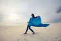 Girl, with a flying blue scarf, is posing in the desert Royalty Free Stock Photo