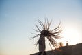 Girl with flying dreadlocks at sunset in profile