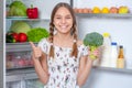 Girl with food near fridge Royalty Free Stock Photo