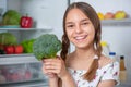 Girl with food near fridge Royalty Free Stock Photo