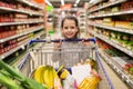 Girl with food in shopping cart at grocery store Royalty Free Stock Photo