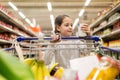 Girl with food in shopping cart at grocery store Royalty Free Stock Photo