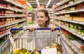 Girl with food in shopping cart at grocery store Royalty Free Stock Photo