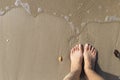 Girl foot on find sand beach with foot print, steping back Royalty Free Stock Photo