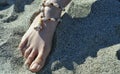 A girl foot with a shell necklace