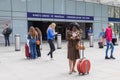 A girl in the form of a stewardess in the style of the fifties, with a magnificent hairstyle on her head, looks into the phone. A