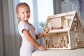 A girl playing with a dollhouse