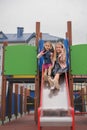 Girl with fractures arm and cast, laughing and shouting, descends from slide Royalty Free Stock Photo