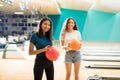 Girl With Friend Standing At Bowling Alley In Club