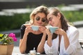 Girl friends in cafe outdoor. Outdoors portrait of two young beautiful women friends drinking coffee. Royalty Free Stock Photo