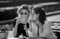 Girl friends in cafe outdoor. Outdoors portrait of two young beautiful women friends drinking coffee. Two beautiful Royalty Free Stock Photo
