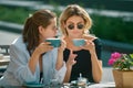 Girl friends in cafe outdoor. Outdoors portrait of two young beautiful women friends drinking coffee. Two beautiful Royalty Free Stock Photo