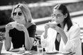 Girl friends in cafe outdoor. Two beautiful girls with cups coffee in summer cafe. Outdoors portrait of two young Royalty Free Stock Photo