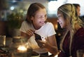 Girl friends having a dinner together at a rooftop bar using a s Royalty Free Stock Photo