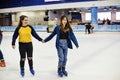 Girl friends ice skating on the ice rink together Royalty Free Stock Photo