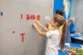 Girl with friends near wall playing lego