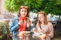 Girl friends students eating Currywurst fast food German dish pork sausage in outdoor street food cafe