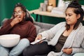 Girl friends, watching tv and remote in home living room on a couch with snack eating. Series, movie and women together Royalty Free Stock Photo