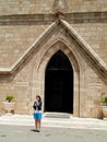 Young woman in front of a church gate