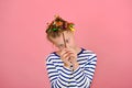 A girl with a funny hairstyle in a striped T-shirt touches her hair, is surprised and makes funny faces