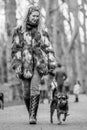 A girl in a fur coat walking her dog in the park at a dog show Royalty Free Stock Photo