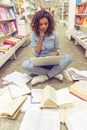 Girl with gadget at the bookshop Royalty Free Stock Photo